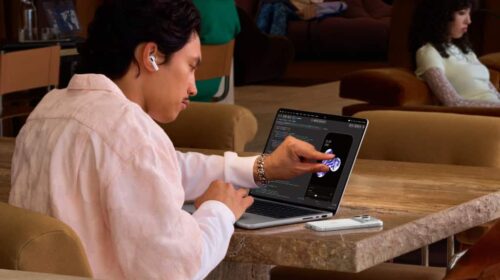 Pessoa tocando na tela de um MacBook