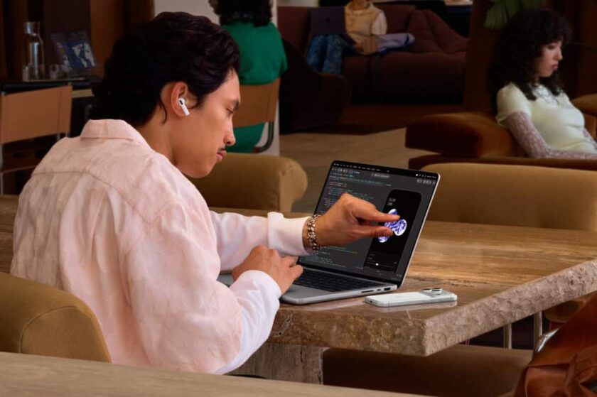 Pessoa tocando na tela de um MacBook